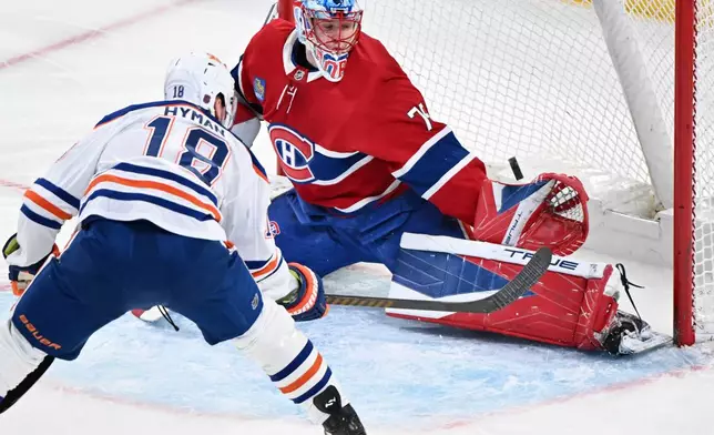 Montreal Canadiens goaltender Jakub Dobes (75) stops Edmonton Oilers' Zach Hyman (18) during the first period of an NHL hockey game, in Montreal, Sunday, Dec. 14, 2025. (Graham Hughes/The Canadian Press via AP)