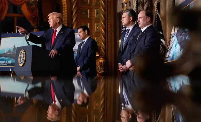 President Donald Trump speaks, with from left, Secretary of State Marco Rubio, Defense Secretary Pete Hegseth and Secretary of the Navy John Phelan,at his Mar-a-Lago club, Monday, Dec. 22, 2025, in Palm Beach, Fla. (AP Photo/Alex Brandon)