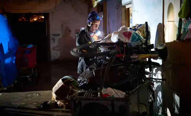 A migrant gathers his belongings as police carry out eviction orders at an abandoned school building where hundreds of mostly undocumented migrants had been living, in Badalona, near Barcelona, Spain, Wednesday, Dec. 17, 2025. (AP Photo/Emilio Morenatti)