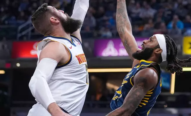 Indiana Pacers forward Isaiah Jackson (22) shoots over Denver Nuggets center Jonas Valanciunas (17) during the first half of an NBA basketball game in Indianapolis, Wednesday, Dec. 3, 2025. (AP Photo/Michael Conroy)