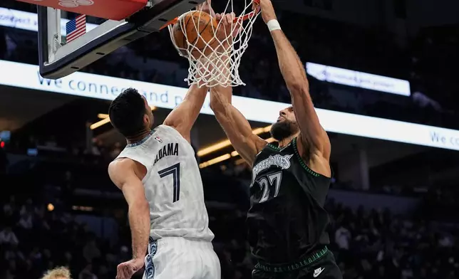 Minnesota Timberwolves center Rudy Gobert (27) dunks against Memphis Grizzlies forward Santi Aldama (7) during the first half of an NBA basketball game, Wednesday, Dec. 17, 2025, in Minneapolis. (AP Photo/Abbie Parr)