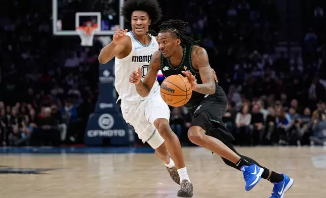 Minnesota Timberwolves guard Bones Hyland (8) works toward the basket as Memphis Grizzlies forward Jaylen Wells (0) defends during the first half of an NBA basketball game, Wednesday, Dec. 17, 2025, in Minneapolis. (AP Photo/Abbie Parr)