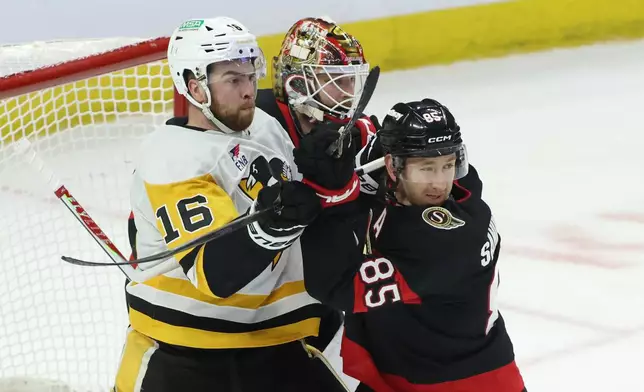 Pittsburgh Penguins' Justin Brazeau (16) and Ottawa Senators' Jake Sanderson (85) battle in front of Senators goaltender Linus Ullmark, center, during second-period NHL hockey game action in Ottawa, Ontario, Thursday, Dec. 18, 2025. (Patrick Doyle/The Canadian Press via AP)