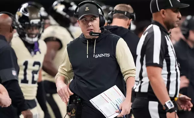 New Orleans Saints head coach Kellen Moore walks on the sideline during the first half of an NFL football game against the New York Jets, Sunday, Dec. 21, 2025, in New Orleans. (AP Photo/Gerald Herbert)