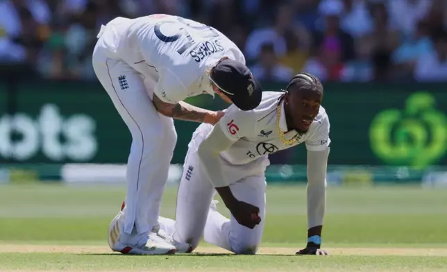England's Jofra Archer is congratulated by teammate Ben Stokes after taking a catch off his own bowling to dismiss Australia's Scott Boland during play on day four of the third Ashes cricket test between England and Australia in Adelaide, Australia, Saturday, Dec. 20, 2025. (AP Photo/James Elsby)