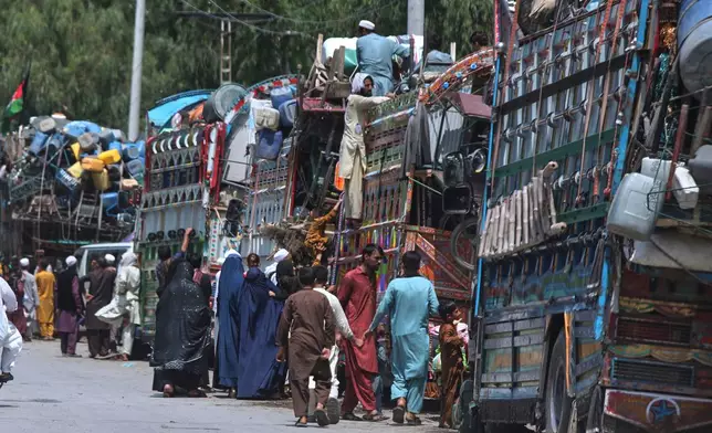 FILE - Afghan refugee families heading back to their homeland, gather next to trucks loaded with their belongings as they wait for documentation at the UNHCR Voluntary Repatriation Centre in Azakhel, Nowshera a district of Pakistan's Khyber Pakhtunkhwa, Monday, Aug. 25, 2025. (AP Photo/Muhammad Sajjad, File)