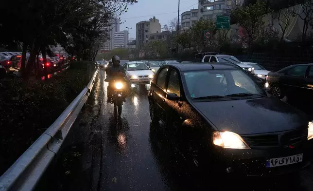People drive on a highway on a rainy day in Tehran, Iran, Wednesday, Dec. 10, 2025. (AP Photo/Vahid Salemi)