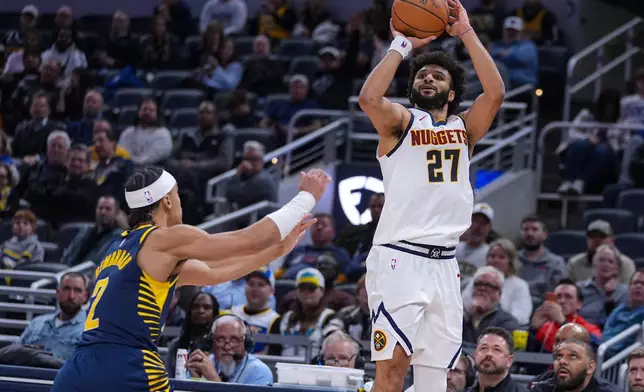 Denver Nuggets guard Jamal Murray (27) hits a three-point basket over Indiana Pacers guard Andrew Nembhard (2) for his 50th point during the second half of an NBA basketball game in Indianapolis, Wednesday, Dec. 3, 2025. (AP Photo/Michael Conroy)