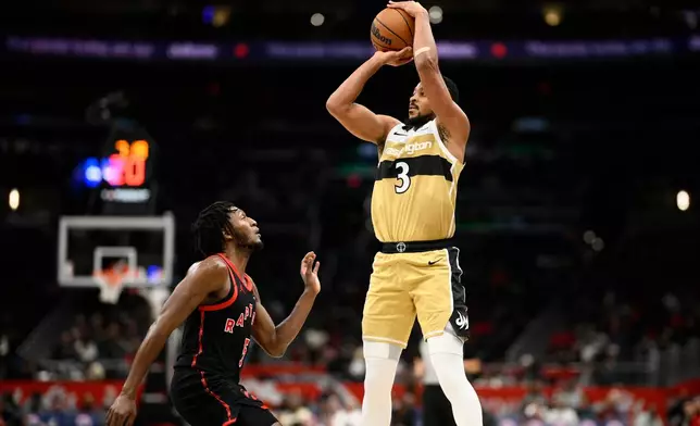 Washington Wizards guard CJ McCollum (3) goes up to shoot against Toronto Raptors guard Immanuel Quickley, left, during the second half of an NBA basketball game, Friday, Dec. 26, 2025, in Washington. (AP Photo/Nick Wass)