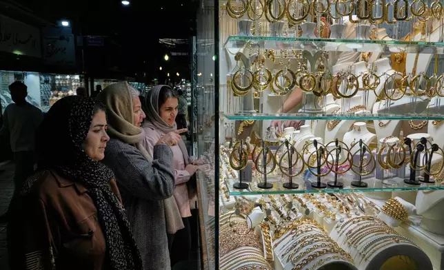 Women look at the window of a gold shop at a gold market in Tehran's Grand Bazaar, Iran, Saturday, Nov. 29, 2025. (AP Photo/Vahid Salemi)