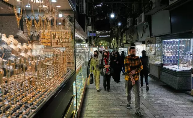 People walk at a gold market in Tehran's Grand Bazaar, Iran, Saturday, Nov. 29, 2025. (AP Photo/Vahid Salemi)