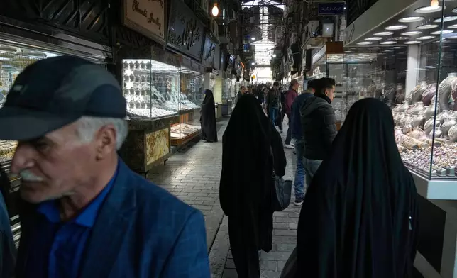 People walk at a gold market in Tehran's Grand Bazaar, Iran, Saturday, Nov. 29, 2025. (AP Photo/Vahid Salemi)