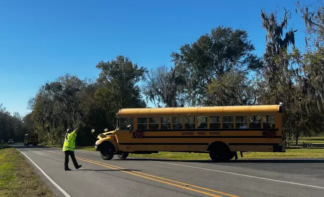 A school bus carries children at the end of a school day at Sixth Ward Middle School in Thibodaux, La., on Dec, 11, 2025. (AP Photo/Stephen Smith)