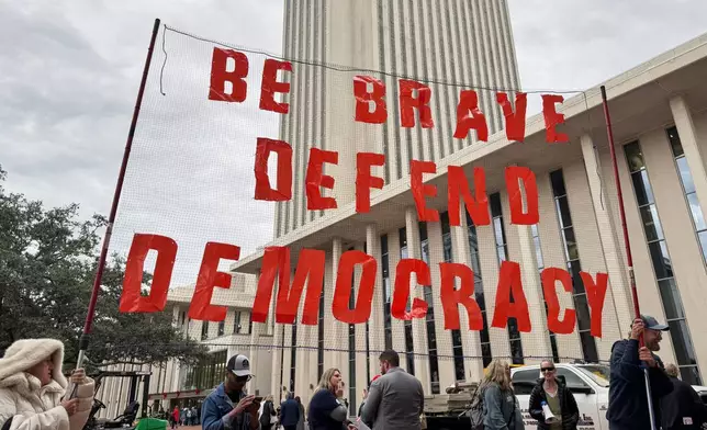 Protestors opposed to mid-decade redistricting hold a sign outside of the Florida Capitol in Tallahassee, Fla. on Dec. 4, 2025. (AP Photo/Kate Payne)