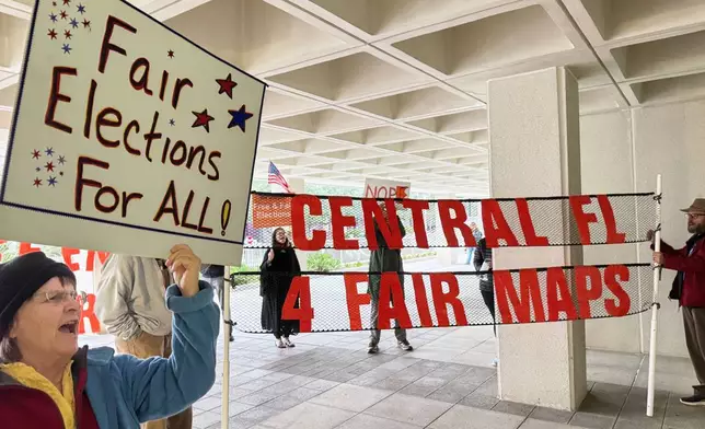 Protestors opposed to mid-decade redistricting wave signs outside of Florida’s Capitol building in Tallahassee, Fla. on Dec. 4, 2025. (AP Photo/Kate Payne)