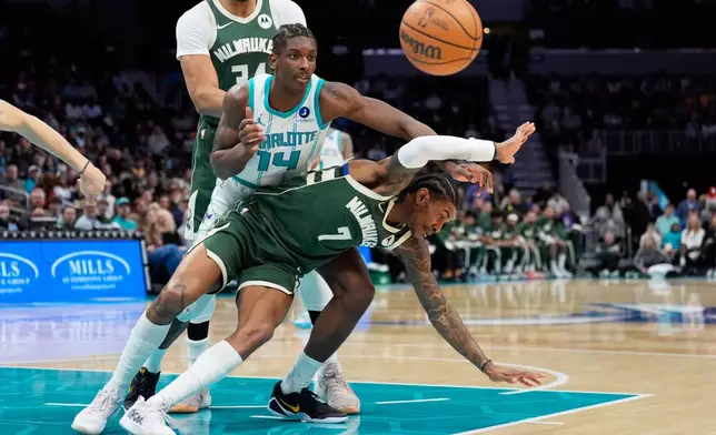 Charlotte Hornets forward Moussa Diabate vies for the ball with Milwaukee Bucks guard Kevin Porter Jr. during the first half of an NBA basketball game, Monday, Dec. 29, 2025, in Charlotte, N.C. (AP Photo/Chris Carlson)