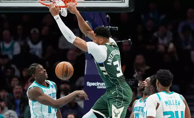 Milwaukee Bucks forward Giannis Antetokounmpo dunks over Charlotte Hornets forward Moussa Diabate during the first half of an NBA basketball game, Monday, Dec. 29, 2025, in Charlotte, N.C. (AP Photo/Chris Carlson)