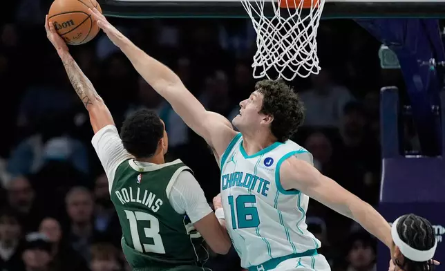 Charlotte Hornets' PJ Hall blocks a shot by Milwaukee Bucks guard Ryan Rollins during the first half of an NBA basketball game, Monday, Dec. 29, 2025, in Charlotte, N.C. (AP Photo/Chris Carlson)