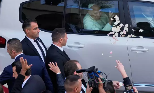 Rose petals are scattered to Pope Leo XIV as he leaves after visiting the Psychiatric Hospital of the Cross in the town of Jal el-Dib, north of Beirut, Lebanon, Tuesday, Dec. 2, 2025. (AP Photo/Hassan Ammar)