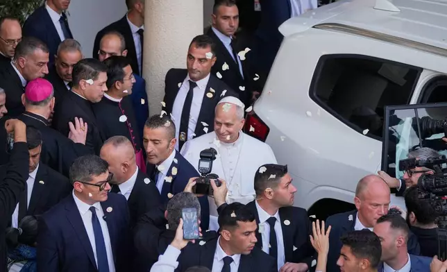 Rose petals are scattered to Pope Leo XIV as he leaves after visiting the Psychiatric Hospital of the Cross in the town of Jal el-Dib, north of Beirut, Lebanon, Tuesday, Dec. 2, 2025. (AP Photo/Hassan Ammar)