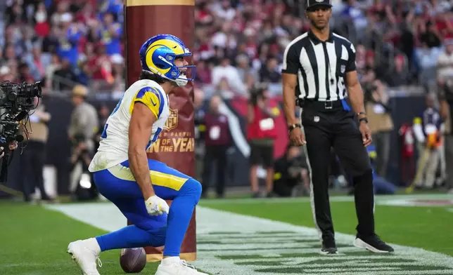 Los Angeles Rams wide receiver Puka Nacua, left, reacts after scoring a touchdown against the Arizona Cardinals in the first half of an NFL football game Sunday, Dec. 7, 2025, in Glendale, Ariz. (AP Photo/Rick Scuteri)