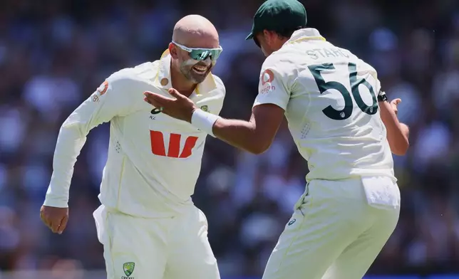 Australia's Nathan Lyon, left, celebrates with teammate Mitchell Starc after dismissing England's Ben Duckett during play on day two of the third Ashes cricket test between England and Australia in Adelaide, Australia, Thursday, Dec. 18, 2025. (AP Photo/James Elsby)