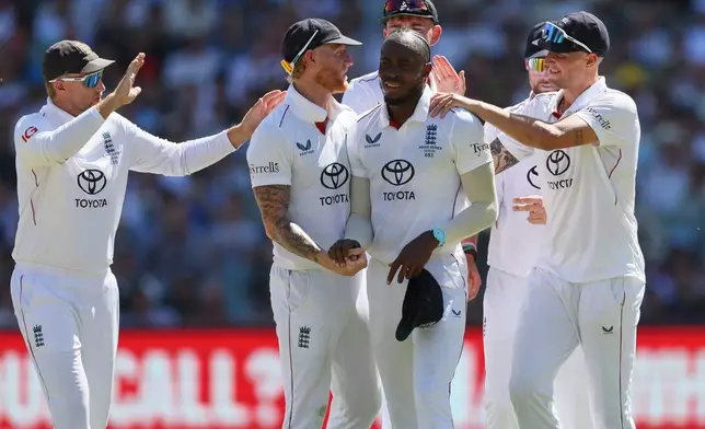 England's Jofra Archer, centre, is congratulated by teammates after taking five wickets during play on day two of the third Ashes cricket test between England and Australia in Adelaide, Australia, Thursday, Dec. 18, 2025. (AP Photo/James Elsby)