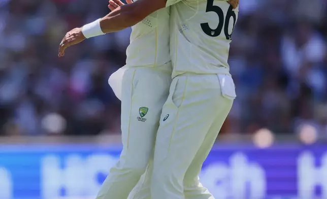 Australia's Nathan Lyon, left, celebrates with teammate Mitchell Starc after dismissing England's Ben Duckett during play on day two of the third Ashes cricket test between England and Australia in Adelaide, Australia, Thursday, Dec. 18, 2025. (AP Photo/James Elsby)