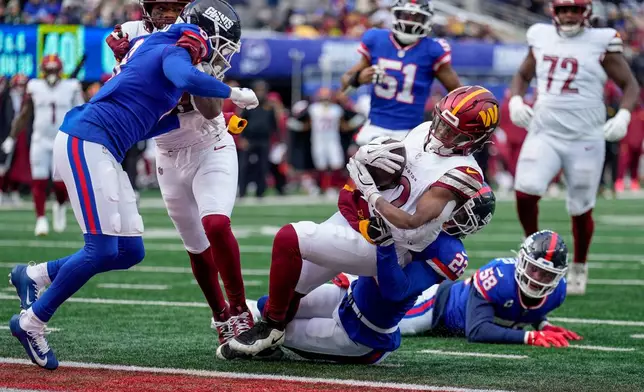 Washington Commanders running back Jacory Croskey-Merritt (22) is tackled by New York Giants cornerback Andru Phillips (22) as he crosses the goal line for a touchdown during the second quarter of an NFL football game, Sunday, Dec. 14, 2025, in East Rutherford, N.J. (AP Photo/Seth Wenig)