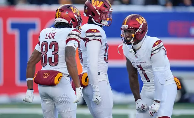 Washington Commanders wide receiver Jaylin Lane (83) celebrates with wide receiver Deebo Samuel Sr. (1) after returning a punt for a touchdown against the New York Giants during the second quarter of an NFL football game, Sunday, Dec. 14, 2025, in East Rutherford, N.J. (AP Photo/Seth Wenig)