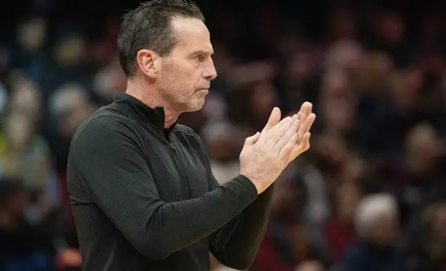 Cleveland Cavaliers head coach Kenny Atkinson applauds his team during the first half of an NBA basketball game against the Golden State Warriors in Cleveland, Saturday, Dec. 6, 2025. (AP Photo/Phil Long)