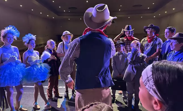 FILE - Callum Ganz, 17, center, gives a pre-show pep talk to castmates in Crazy for You on opening night as the Theatre Palisades Youth group returns to the stage after losing their theater in the Palisades fire, in Los Angeles, Feb. 28, 2025. (AP Photo/Jocelyn Gecker, File)