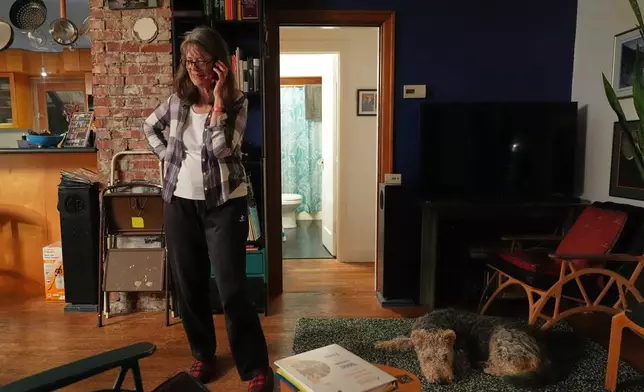 FILE - Mary E. Brunkow speaks on the phone during an interview after winning a Nobel Prize in medicine for part of her work on peripheral immune tolerance, in Seattle, Oct. 6, 2025, next to her is her dog Zelda. (AP Photo/Lindsey Wasson, File)