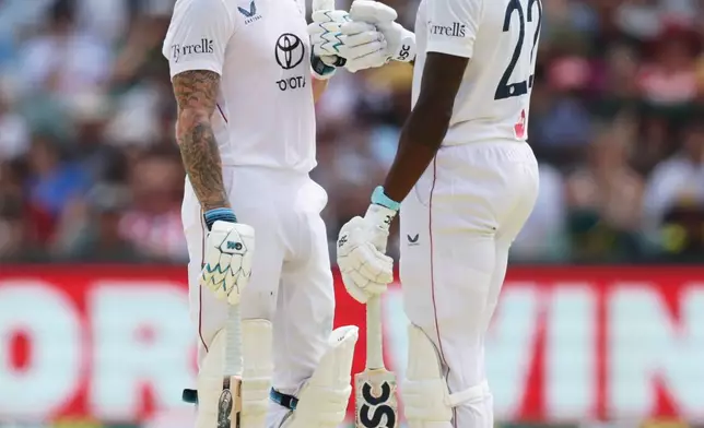 England batsmen Jofra Archer, right, and Ben Stokes talk during play on day three of the third Ashes cricket test between England and Australia in Adelaide, Australia, Friday, Dec. 19, 2025. (AP Photo/James Elsby)