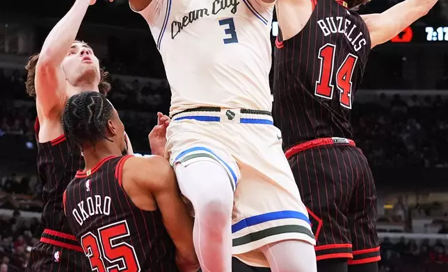 Milwaukee Bucks center Myles Turner (3) drives to the basket against Chicago Bulls guard Josh Giddey, left, forward Isaac Okoro (35) and forward Matas Buzelis (14) during the first half of an NBA basketball game in Chicago, Saturday, Dec. 27, 2025. (AP Photo/Nam Y. Huh)