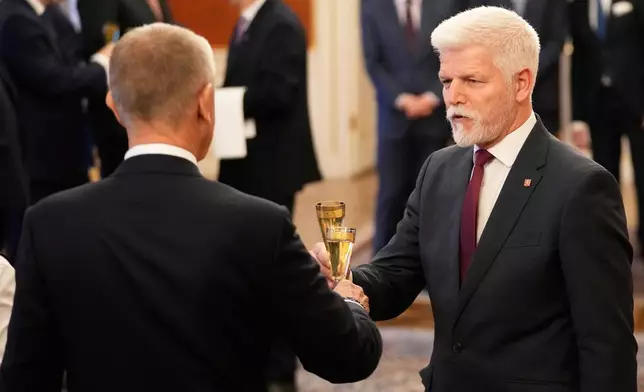 Czech Republic's President Petr Pavel, right, toasts with Prime Minister Andrej Babis after appointing his government members at the Prague Castle in Prague, Czech Republic, Monday, Dec. 15, 2025. (AP Photo/Petr David Josek)