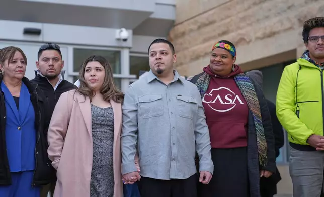 Kilmar Abrego Garcia, center, holds hands with his wife Jennifer Vasquez Sura while leaving the United States District Court District of Maryland, Monday, Dec. 22, 2025, in Greenbelt, Md. (AP Photo/Stephanie Scarbrough)