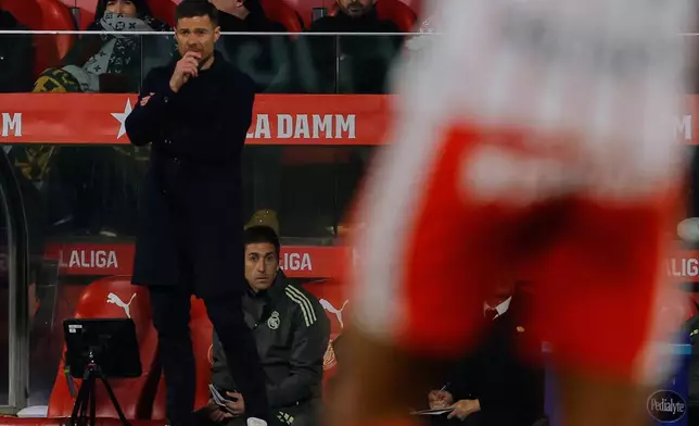 Real Madrid's head coach Xabi Alonso follows the match during a Spanish La Liga soccer match between Girona and Real Madrid, in Girona, Spain, Sunday, Nov. 30, 2025. (AP Photo/Joan Monfort)