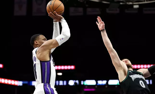 Sacramento Kings guard Russell Westbrook, left, looks to shoot as Minnesota Timberwolves guard Donte Divincenzo (0) defends during the second half of an NBA basketball game Sunday, Dec. 14, 2025, in Minneapolis. (AP Photo/Matt Krohn)