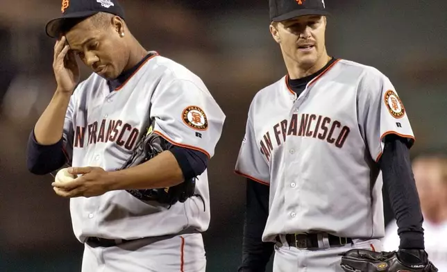 FILE - San Francisco Giants Livan Hernandez, left, and Jeff Kent react after the Anaheim Angels Garret Anderson hit a three run RBI double in the third inning during game 7 of the World Series in Anaheim, Calif., on Oct. 27, 2002. (AP Photo/Mark J. Terrill, File)