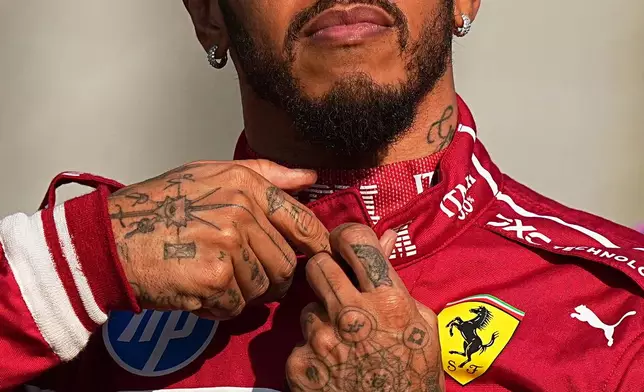 Ferrari driver Lewis Hamilton of Britain prepares for the drivers parade ahead of the Formula One Abu Dhabi Grand Prix at the Yas Marina Circuit in Abu Dhabi, UAE, Sunday, Dec. 7, 2025. (AP Photo/Fatima Shbair)