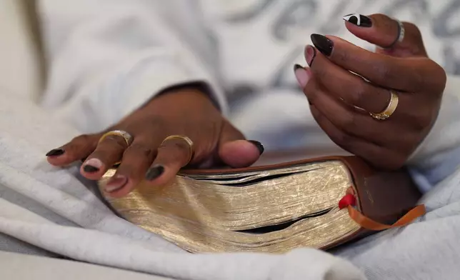 Megan Ashley, founder of the Christian podcast, "In Totality," sits with a Bible at her home where she films online content, Saturday, Nov. 15, 2025, in Acworth, Ga. (AP Photo/Jessie Wardarski)