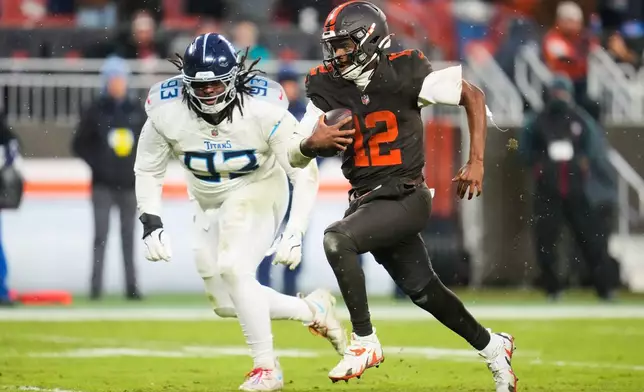 Cleveland Browns quarterback Shedeur Sanders (12) runs the ball for a touchdown as Tennessee Titans defensive tackle T'Vondre Sweat (93) gives chase in the second half of an NFL football game in Cleveland, Sunday, Dec. 7, 2025. (AP Photo/Sue Ogrocki)
