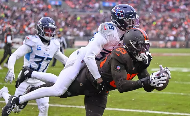 Cleveland Browns tight end David Njoku (85) catches a touchdown pass as Tennessee Titans cornerback Darrell Baker Jr. (39) defends in the first half of an NFL football game in Cleveland, Sunday, Dec. 7, 2025. (AP Photo/David Richard)