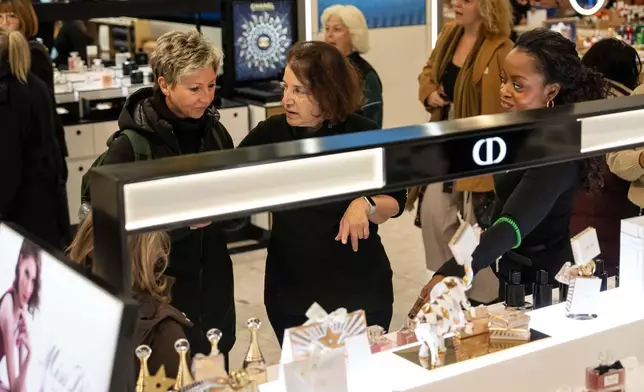 Associated Press reporter Anne D'Innocenzio helps out a customer at Macy's flagship store, Friday, Nov. 21, 2025, in New York. (AP Photo/Yuki Iwamura)