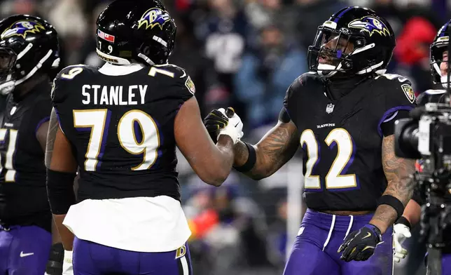 Baltimore Ravens running back Derrick Henry (22) is congratulated by offensive tackle Ronnie Stanley (79) after scoring against the New England Patriots during the second half of an NFL football game, Sunday, Dec. 21, 2025, in Baltimore. (AP Photo/Nick Wass)