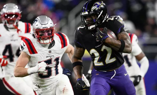 Baltimore Ravens running back Derrick Henry (22) runs against New England Patriots linebacker Jack Gibbens (51) during the second half of an NFL football game, Sunday, Dec. 21, 2025, in Baltimore. (AP Photo/Nick Wass)