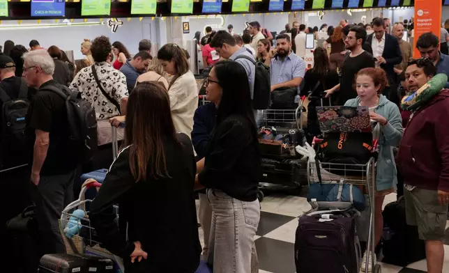 People wait to board at Congonhas Airport after the cancellation of several flights during a blackout in Sao Paulo, Thursday, Dec. 11, 2025. (AP Photo/Ettore Chiereguini)