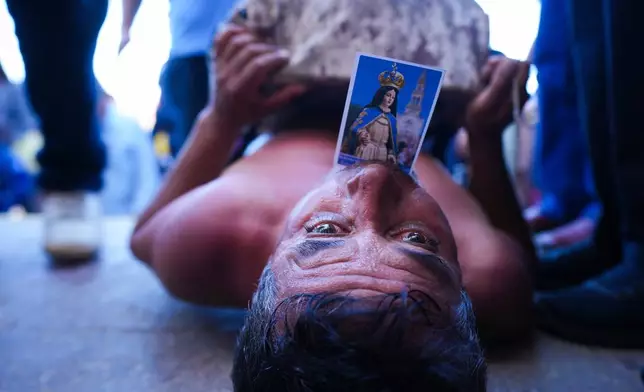 A pilgrim crawls to the Sanctuary of Lo Vasquez during an annual celebration marking the Immaculate Conception of the Virgin Mary, in Valparaiso, Chile, Monday, Dec. 8, 2025. (AP Photo/Esteban Felix)