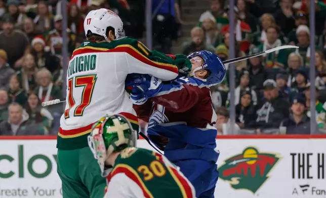 Minnesota Wild left wing Marcus Foligno (17) cross checks Colorado Avalanche center Gavin Brindley during the second period of an NHL hockey game, Sunday, Dec. 21, 2025, in St. Paul, Minn. (AP Photo/Bailey Hillesheim)